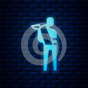 Glowing neon Human broken arm icon isolated on brick wall background. Injured man in bandage. Vector