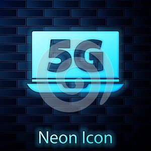 Glowing neon Laptop with 5G new wireless internet wifi icon isolated on brick wall background. Global network high speed