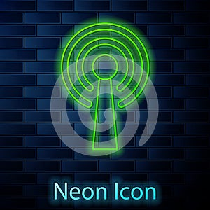 Glowing neon line Antenna icon isolated on brick wall background. Radio antenna wireless. Technology and network signal