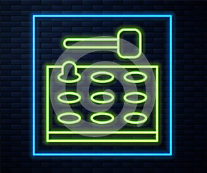 Glowing neon line Arcade game machine with hammer icon isolated on brick wall background. Amusement park attraction