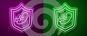 Glowing neon line Baby on shield icon isolated on purple and green background. Child safety sign. Vector