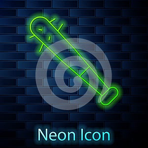 Glowing neon line Baseball bat with nails icon isolated on brick wall background. Violent weapon. Vector