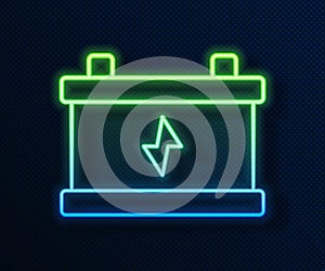 Glowing neon line Car battery icon isolated on blue background. Accumulator battery energy power and electricity