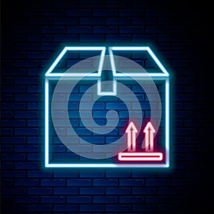 Glowing neon line Cardboard box with traffic symbol icon isolated on brick wall background. Box, package, parcel sign