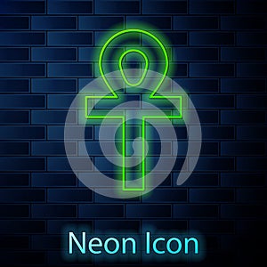 Glowing neon line Cross ankh icon isolated on brick wall background. Vector Illustration