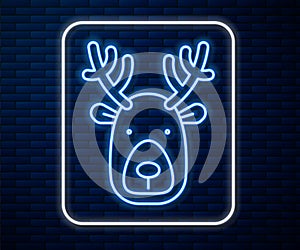 Glowing neon line Deer head with antlers icon isolated on brick wall background. Vector