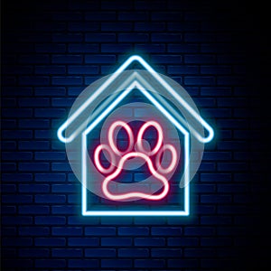 Glowing neon line Dog house and paw print pet icon isolated on brick wall background. Dog kennel. Colorful outline