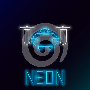 Glowing neon line Drone flying with action video camera icon isolated on black background. Quadrocopter with video and