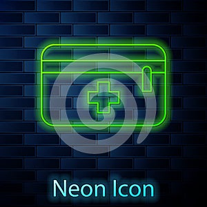 Glowing neon line First aid kit icon isolated on brick wall background. Medical box with cross. Medical equipment for