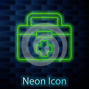Glowing neon line First aid kit icon isolated on brick wall background. Medical box with cross. Medical equipment for