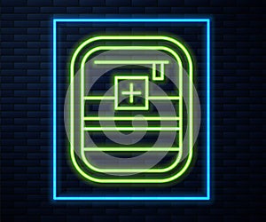 Glowing neon line First aid kit icon isolated on brick wall background. Medical box with cross. Medical equipment for