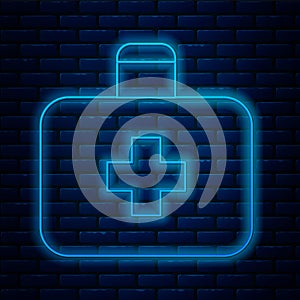 Glowing neon line First aid kit icon isolated on brick wall background. Medical box with cross. Medical equipment for