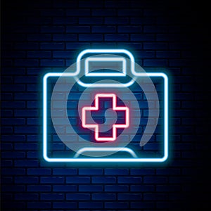 Glowing neon line First aid kit icon isolated on brick wall background. Medical box with cross. Medical equipment for