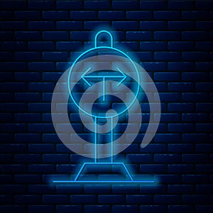 Glowing neon line Fork in the road icon isolated on brick wall background. Vector