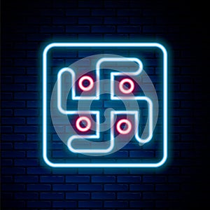 Glowing neon line Jainism icon isolated on brick wall background. Colorful outline concept. Vector