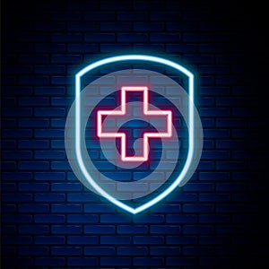 Glowing neon line Medical shield with cross icon isolated on brick wall background. Protection, safety, password