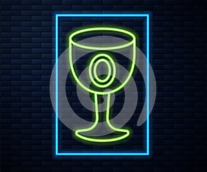 Glowing neon line Medieval goblet icon isolated on brick wall background. Holy grail. Vector