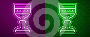 Glowing neon line Medieval goblet icon isolated on purple and green background. Vector
