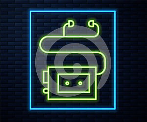 Glowing neon line Museum audio guide icon isolated on brick wall background. Headphones for excursions. Vector
