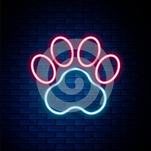 Glowing neon line Paw print icon isolated on brick wall background. Dog or cat paw print. Animal track. Colorful outline