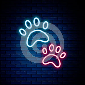 Glowing neon line Paw print icon isolated on brick wall background. Dog or cat paw print. Animal track. Colorful outline