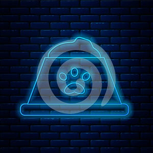 Glowing neon line Pet food bowl for cat or dog icon isolated on brick wall background. Dog or cat paw print. Vector
