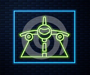 Glowing neon line Plane icon isolated on brick wall background. Flying airplane icon. Airliner sign. Vector