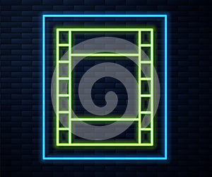 Glowing neon line Play Video icon isolated on brick wall background. Film strip sign. Vector