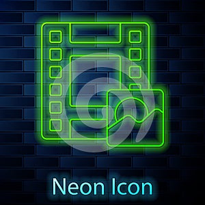 Glowing neon line Play Video icon isolated on brick wall background. Film strip sign. Vector