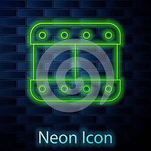 Glowing neon line Play video icon isolated on brick wall background. Film strip sign. Vector