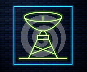 Glowing neon line Satellite dish icon isolated on brick wall background. Radio antenna, astronomy and space research