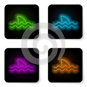 Glowing neon line Shark fin in ocean wave icon isolated on white background. Black square button. Vector