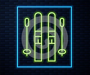 Glowing neon line Ski and sticks icon isolated on brick wall background. Extreme sport. Skiing equipment. Winter sports