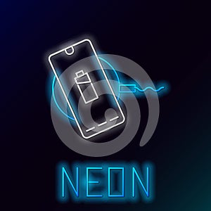 Glowing neon line Smartphone charging on wireless charger icon isolated on black background. Charging battery on