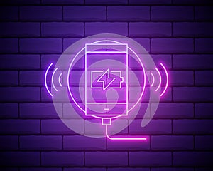 Glowing neon line Smartphone charging on wireless charger icon isolated on brick wall background. Charging battery on