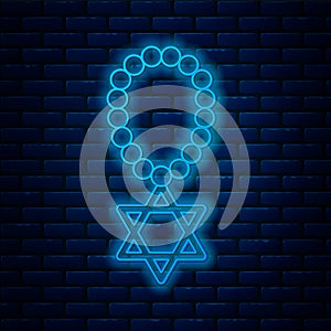 Glowing neon line Star of David necklace on chain icon isolated on brick wall background. Jewish religion symbol. Symbol