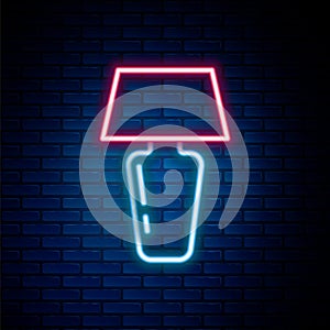 Glowing neon line Table lamp icon isolated on brick wall background. Desk lamp. Colorful outline concept. Vector