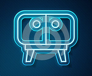 Glowing neon line TV table stand icon isolated on blue background. Vector