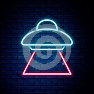 Glowing neon line UFO flying spaceship icon isolated on brick wall background. Flying saucer. Alien space ship
