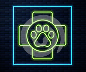 Glowing neon line Veterinary clinic symbol icon isolated on brick wall background. Cross hospital sign. A stylized paw