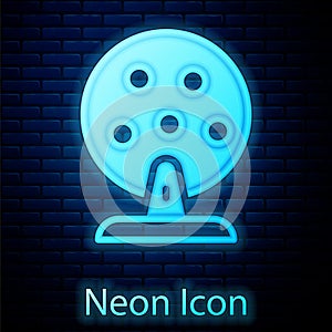 Glowing neon Lottery machine with lottery balls inside icon isolated on brick wall background. Lotto bingo game of luck