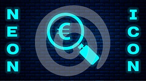 Glowing neon Magnifying glass and euro symbol icon isolated on brick wall background. Find money. Looking for money