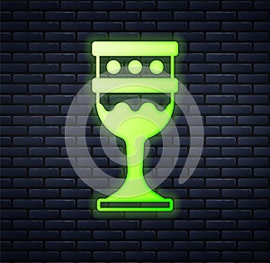Glowing neon Medieval goblet icon isolated on brick wall background. Holy grail. Vector