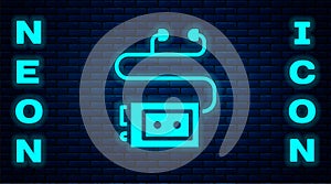 Glowing neon Museum audio guide icon isolated on brick wall background. Headphones for excursions. Vector