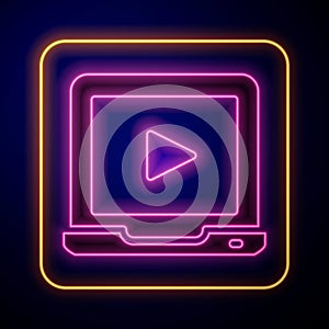 Glowing neon Online play video icon isolated on black background. Laptop and film strip with play sign. Vector