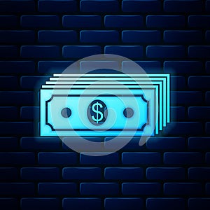 Glowing neon Paper money american dollars cash icon isolated on brick wall background. Money banknotes stack with dollar