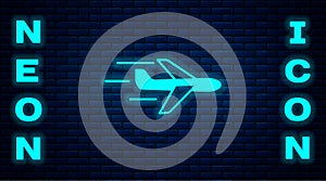 Glowing neon Plane icon isolated on brick wall background. Flying airplane icon. Airliner sign. Vector