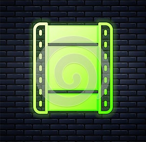 Glowing neon Play video icon isolated on brick wall background. Film strip sign. Vector
