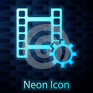 Glowing neon Play Video icon isolated on brick wall background. Film strip sign. Vector