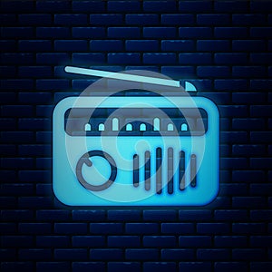 Glowing neon Radio with antenna icon isolated on brick wall background. Vector